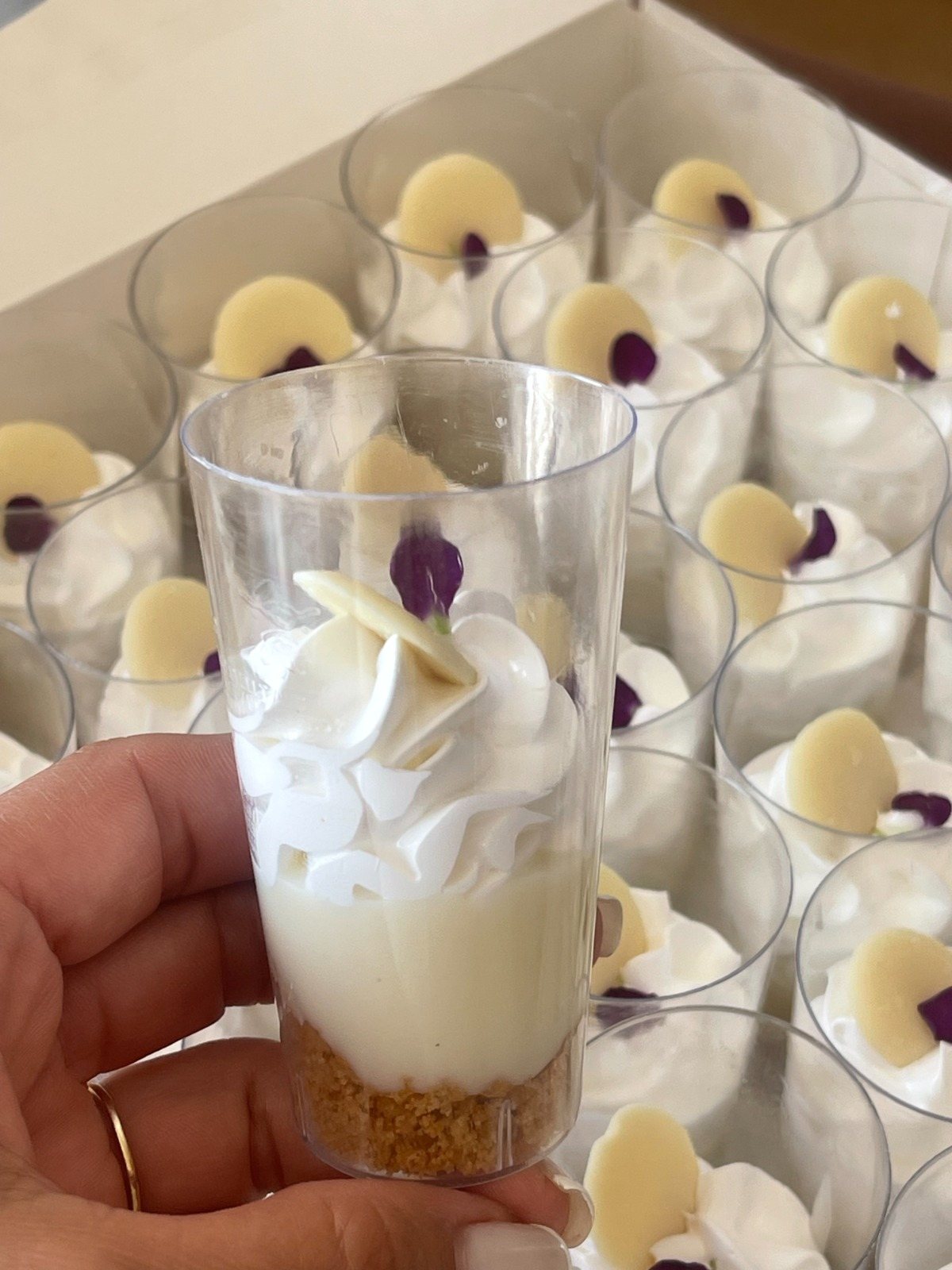 Vasito de merengue y crema en la mano